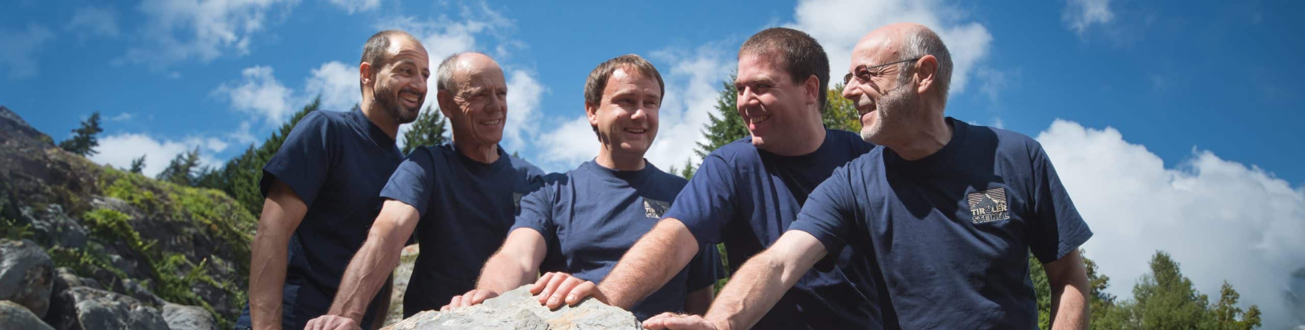 Gruppe von fünf Männern draußen am Felsen.