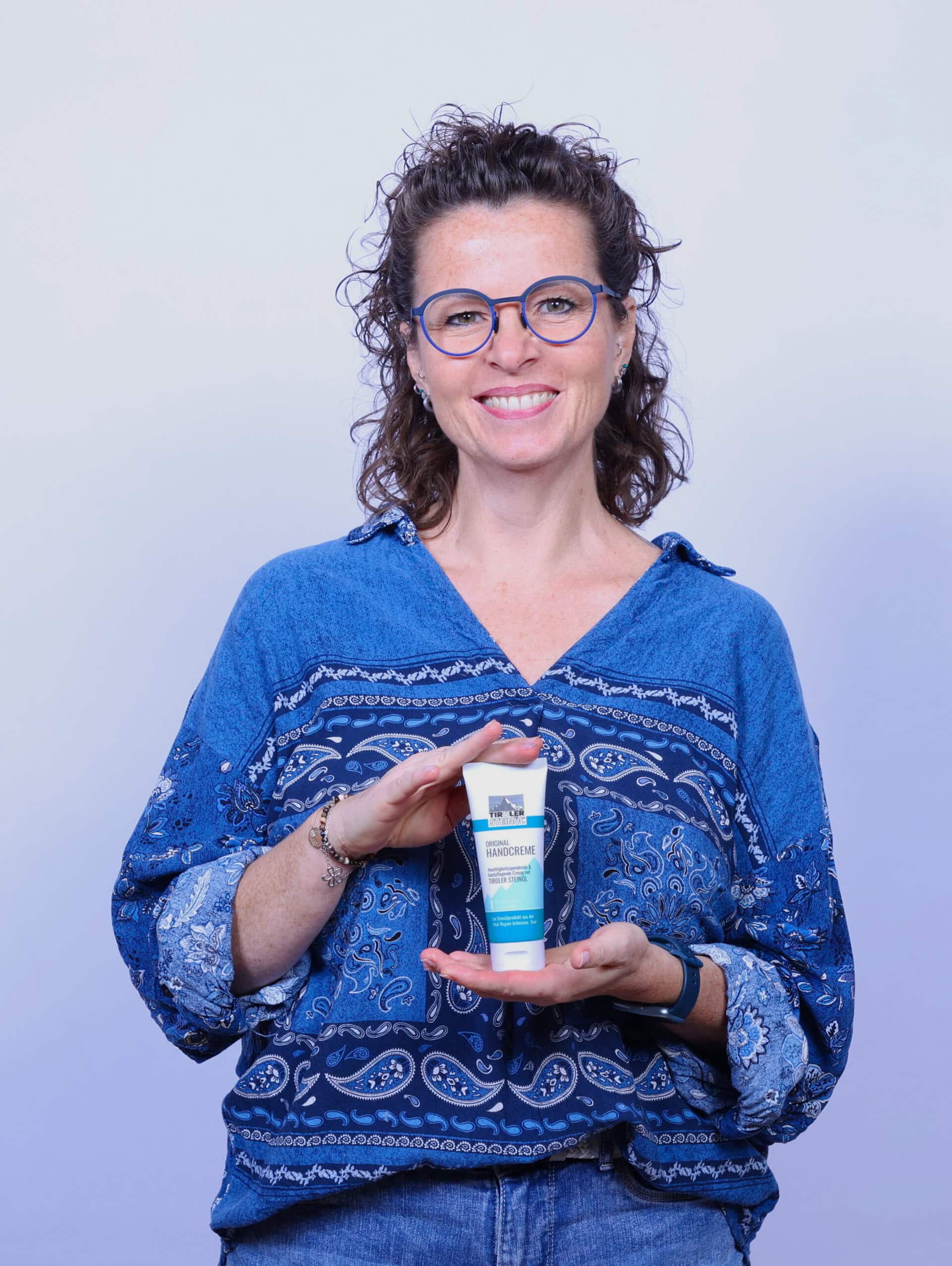 Frau präsentiert Handcreme in der Hand